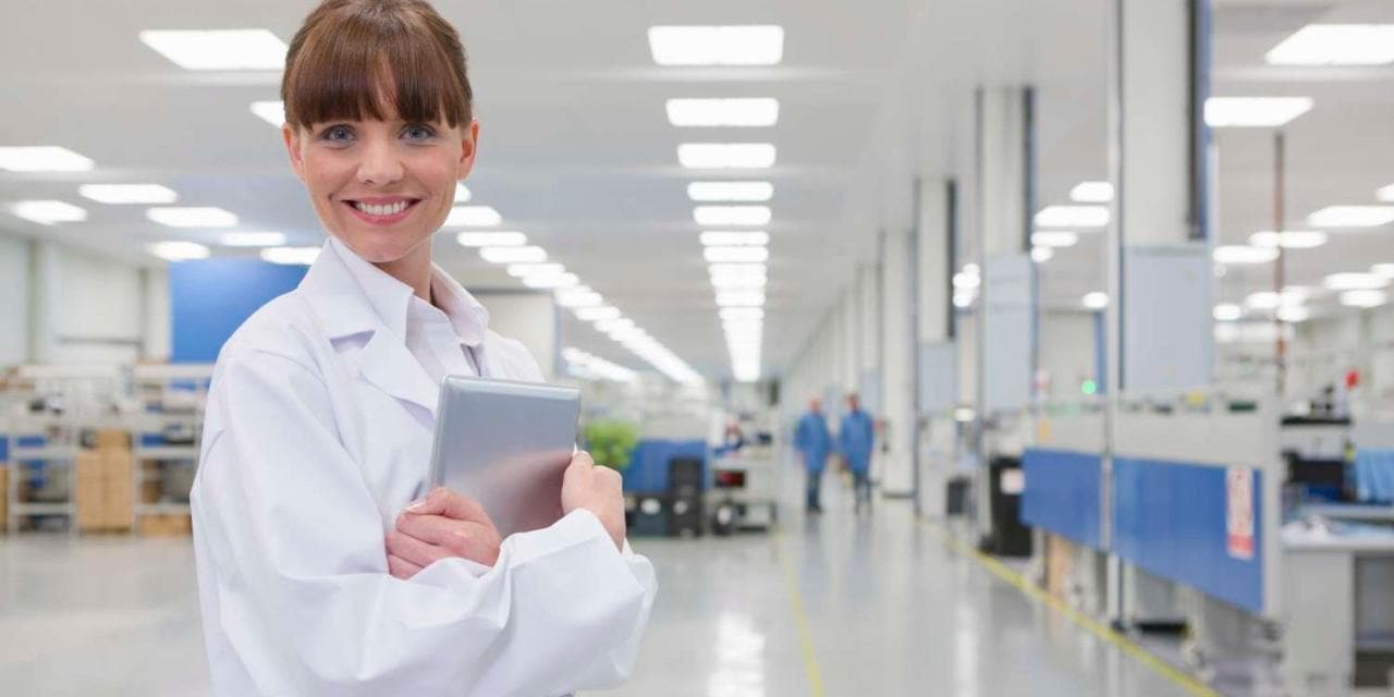 Smiling scientist in high tech manufacturing plant