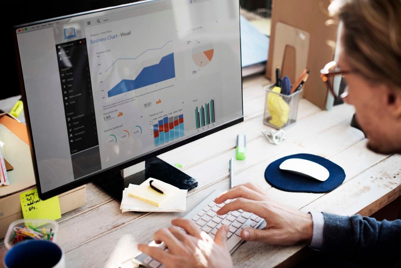 Man looking at charts on wooden desk