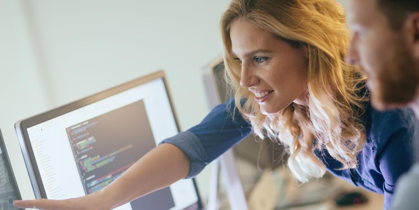 Man Working on Computer and woman pointing on screen Man Working on Computer and woman pointing on screen