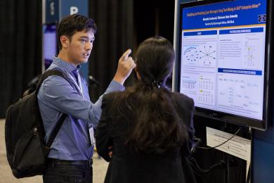 Man and woman discussing e-poster presentation at SAS Global Forum
