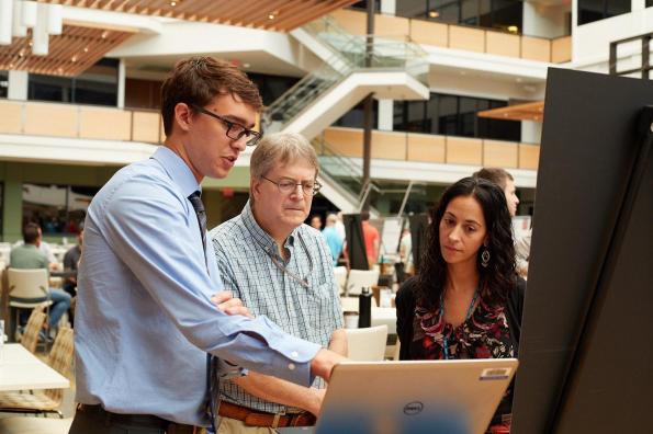 SAS intern presenting work to two employees