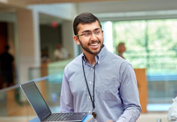 SAS employee smiling with laptop