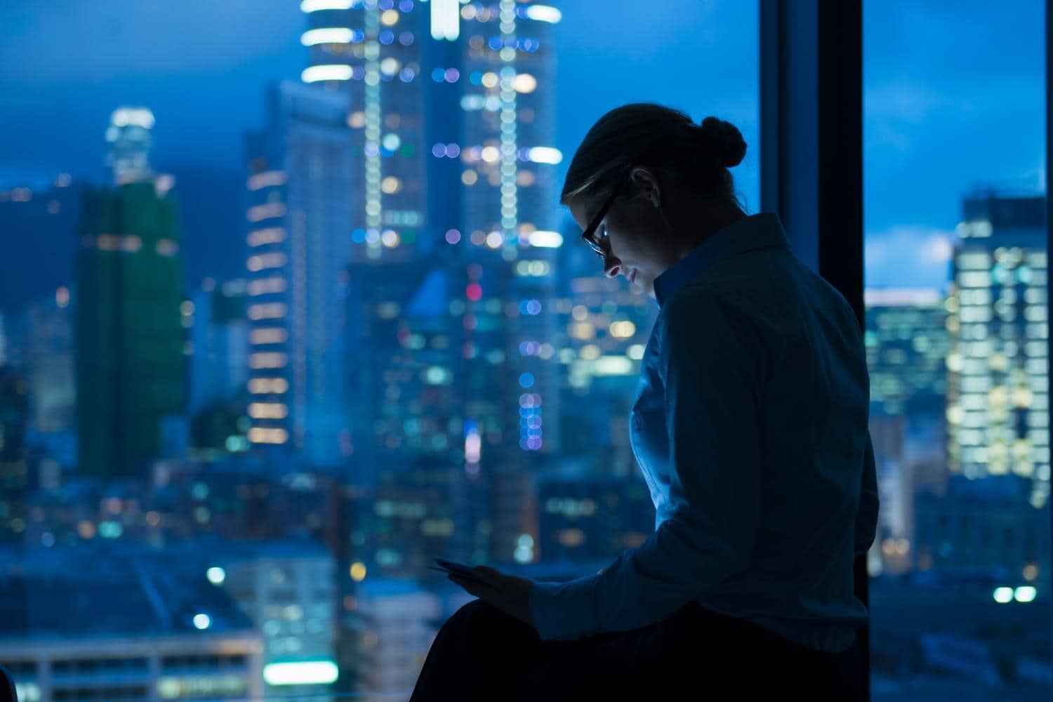 Woman with tablet device working late in office Woman with tablet device working late in office
