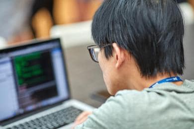 SAS intern coding on laptop