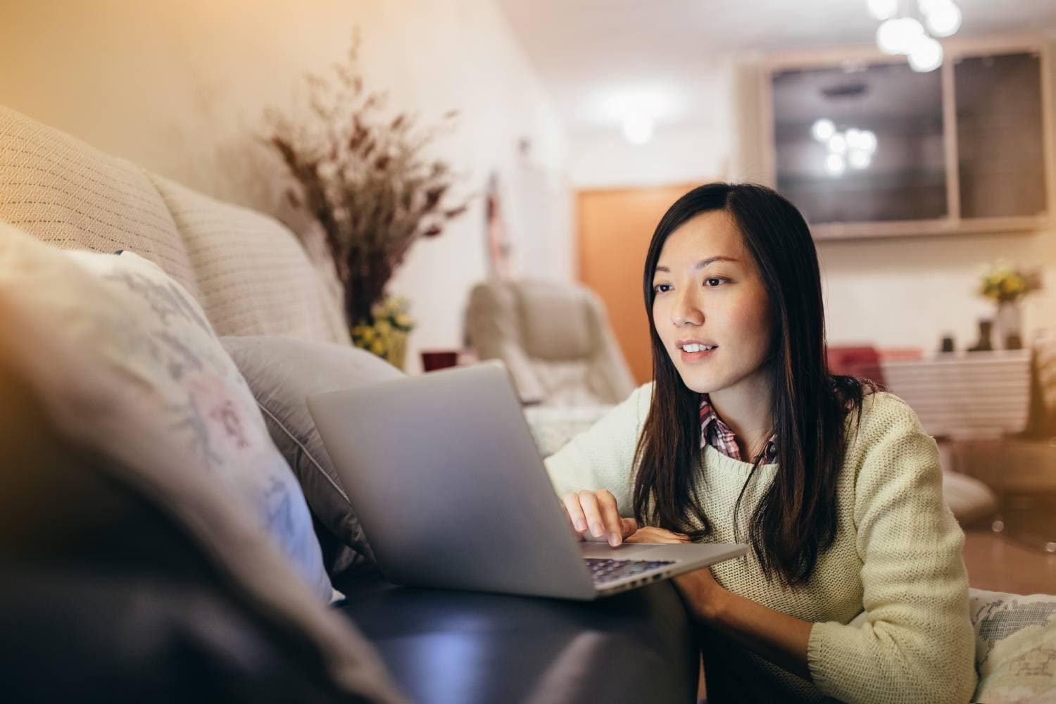 Young woman working on laptop in living room