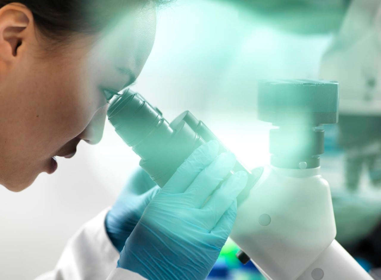 Person looking through microscope