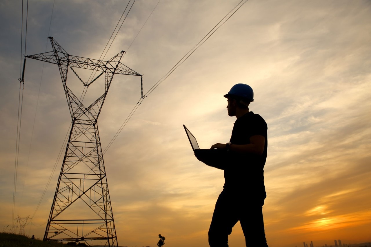 Man inspects electrical tower