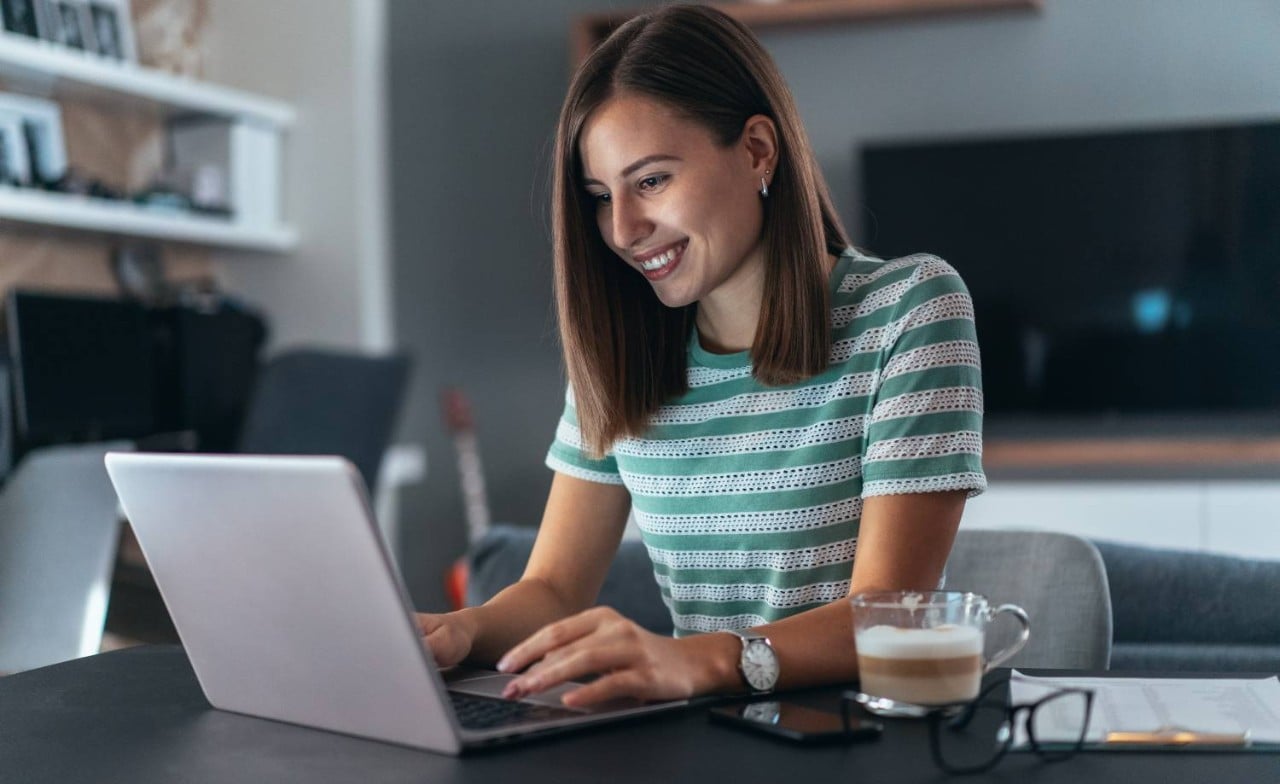 Woman using laptop at desk in home office