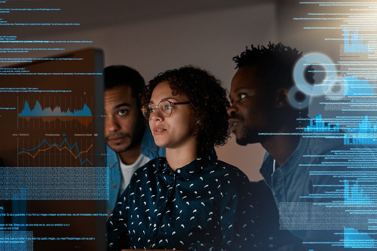 Two men and a woman at work reviewing data on a computer screen