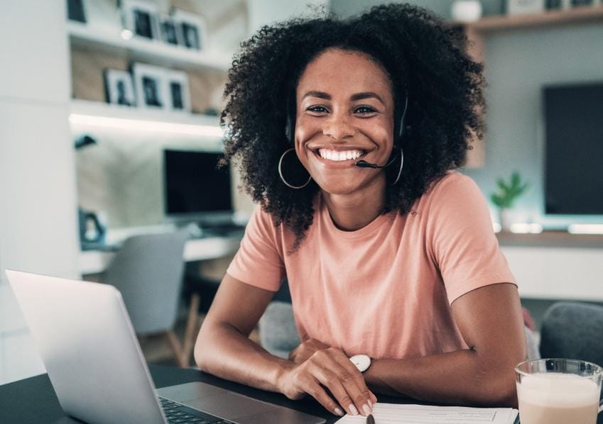 Woman smiling with laptop and headphones