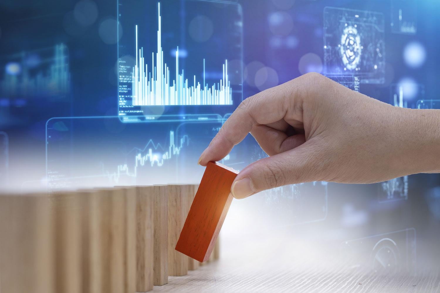 Hand moves wooden block against a data backdrop