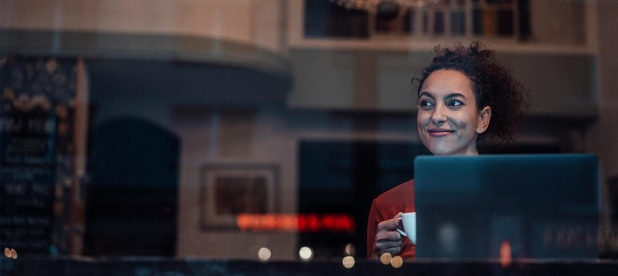 Girl in a coffee shop window with a laptop Girl in a coffee shop window with a laptop