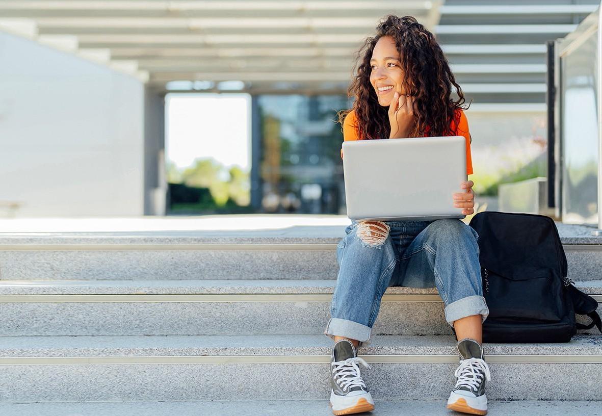 Student sitting in front of academic building