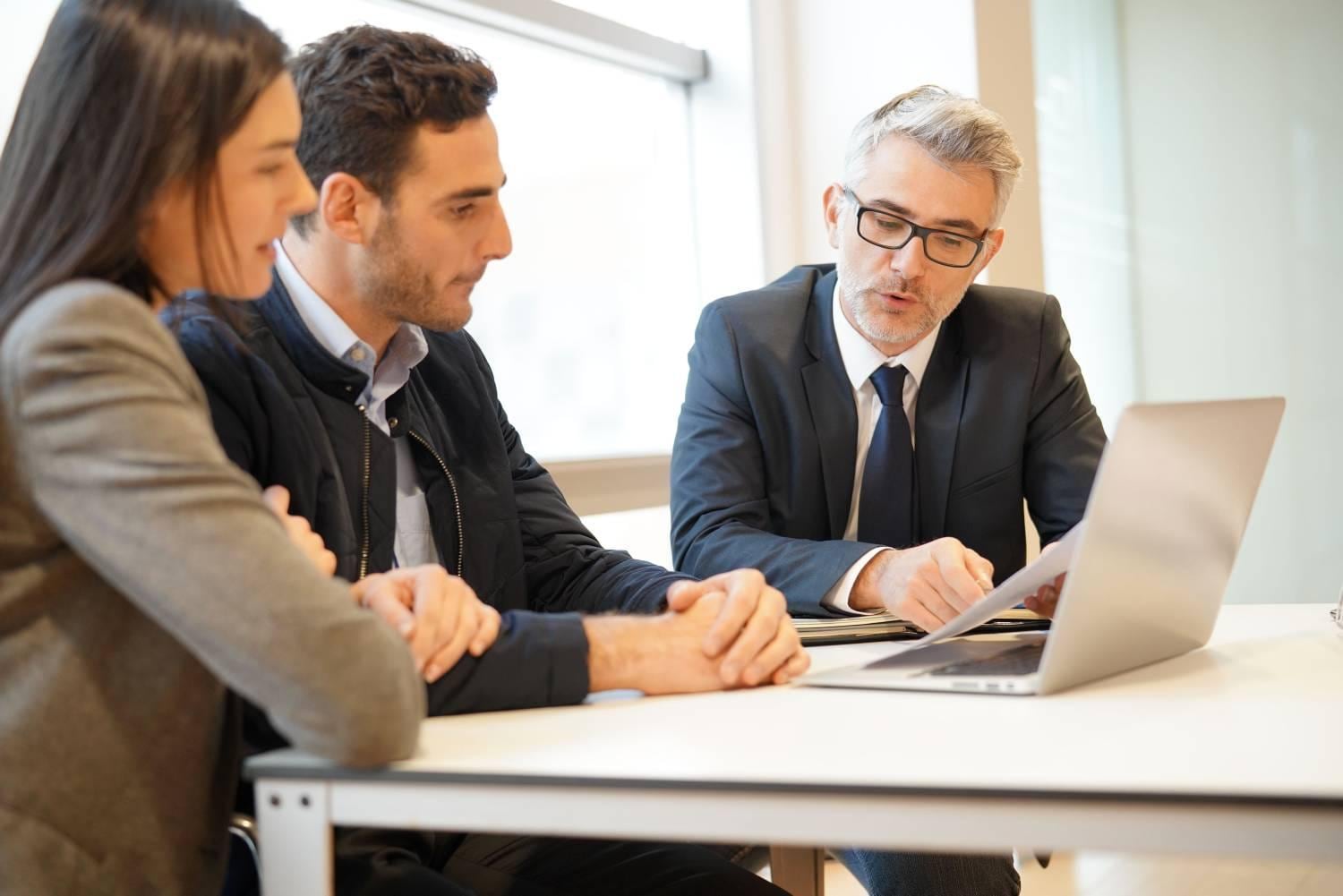 Businessman giving financial consultation to young couple