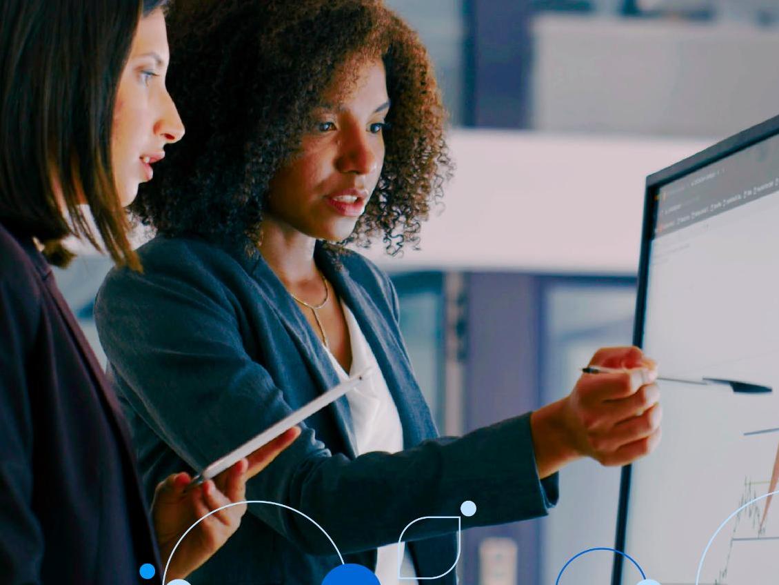 Two women pointing at computer screen