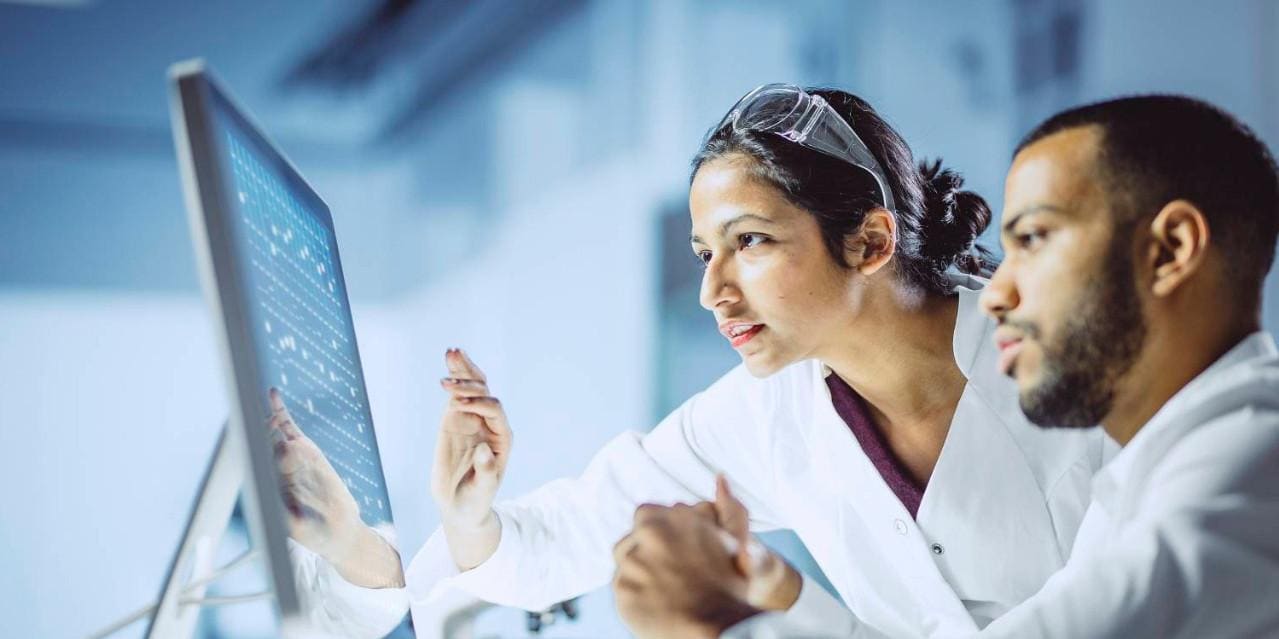 Vision and Mission Two scientists looking at data