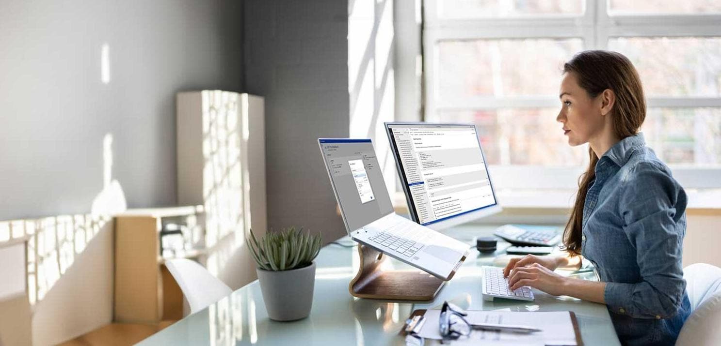 Businesswoman working on two computers