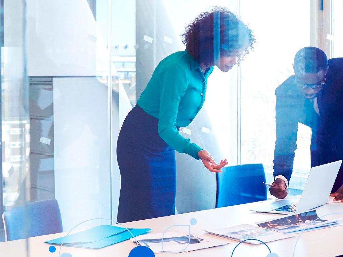 Male and female coworkers viewing data on desktop monitor